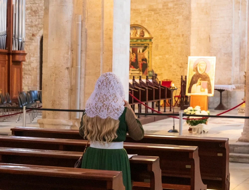Une jeune femme prie dans une église